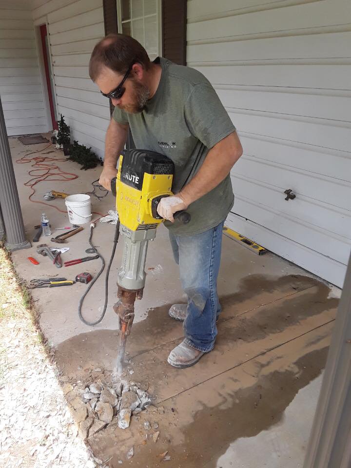 Evenflow Plumbing technician breaking concrete to reach a slab leak in Texarkana